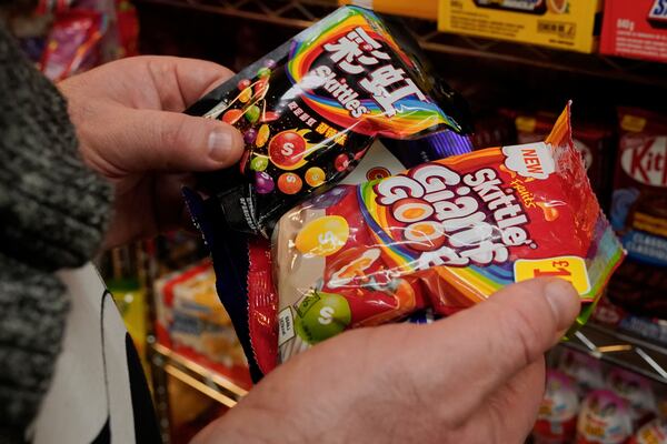 A shopper at Economy Candy chooses Skittles from Japan, at the shop on New York's Lower East Side, Friday, April 4, 2025. (AP Photo/Richard Drew)