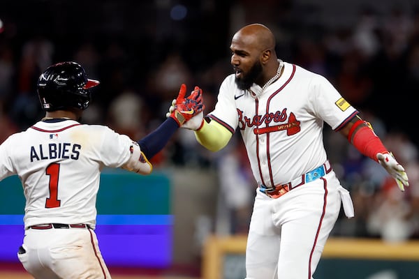 Atlanta Braves designated hitter Marcell Ozuna (20) celebrates with Ozzie Albies (1) after hitting a walk off RBI during the10th inning of a baseball game to beat the Cincinnati Reds, Tuesday, May 6, 2025, in Atlanta. (AP Photo/Butch Dill)