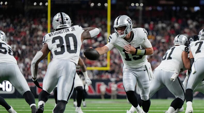 Las Vegas Raiders quarterback Fernando Mendoza (15) hands off to Las Vegas Raiders running back Mike Washington Jr. (30) during the first half of an NFL preseason football game against the Houston Texans, Thursday, Aug. 20, 2026, in Houston. (AP Photo/Ashley Landis)