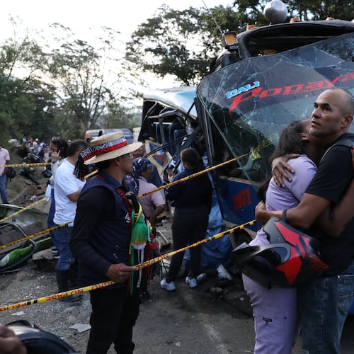Relatives of victims embrace in front of a bus hit by an explosive device on the Pan-American Highway in Cajibio, Colombia, Saturday, April 25, 2026, after an attack blamed by authorities on dissident groups of the former FARC rebels killed at least a dozen people. (AP Photo/Santiago Saldarriaga)