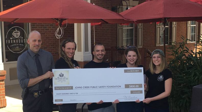 Farmhouse Coffee & Crepes presents a check made out to the Johns Creek Public Safety Foundation for $800.