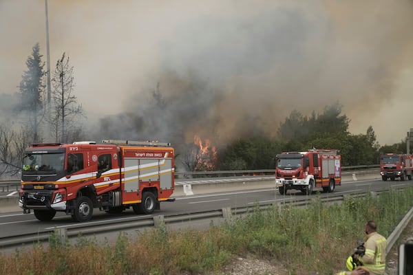 Israeli firefighters work to extinguish a forest fire burning on a freeway to Jerusalem, Wednesday, April 30, 2025. (AP Photo/Mahmoud Illean)