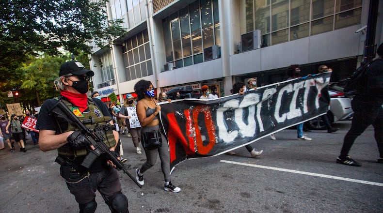 Protesters march through downtown Atlanta in September 2021 to demonstrate against the police training facility being built in unincorporated DeKalb County. 
(Jenni Girtman for The Atlanta Journal-Constitution)