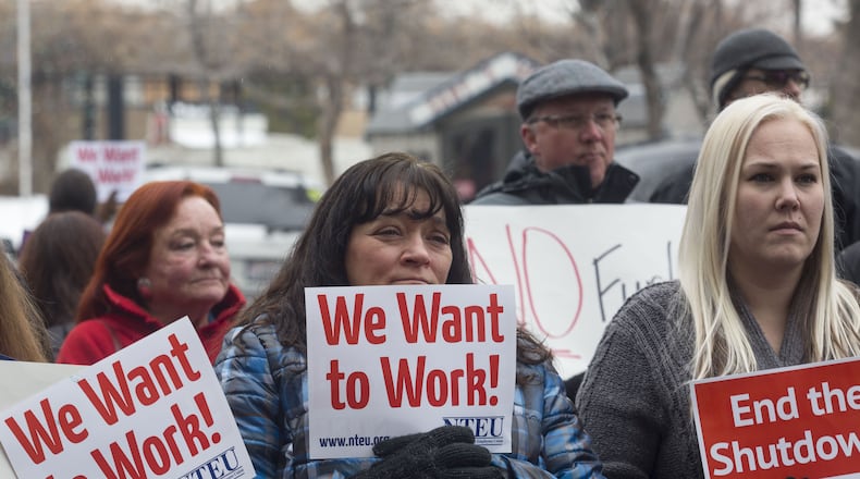 IRS employee Donna Orton, center, holds a sign protesting the government shutdown at the James V. Hansen Federal Building on Jan. 10, 2019 in Ogden, Utah. (Photo by Natalie Behring/Getty Images)