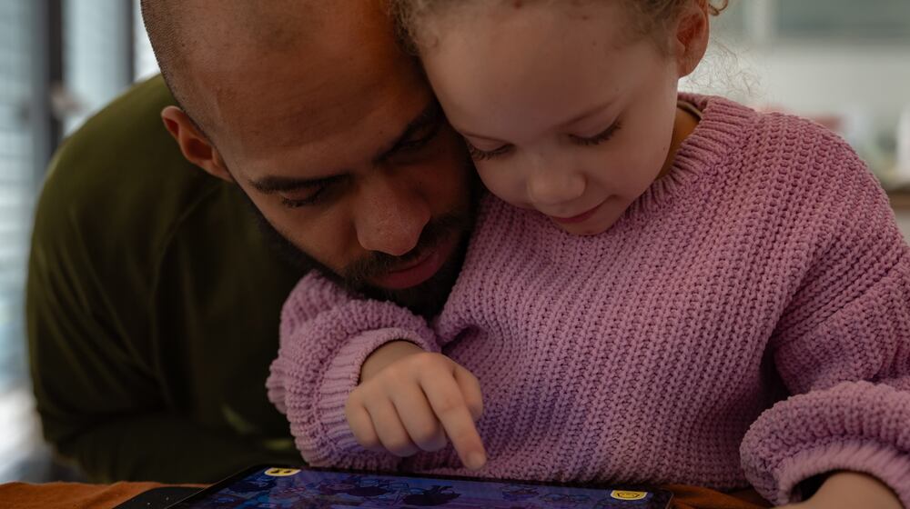 Kasim Edebali and his daughter Yara play a game on a tablet, in Hamburg, Germany. (Patrick Junker/The New York Times 2023)