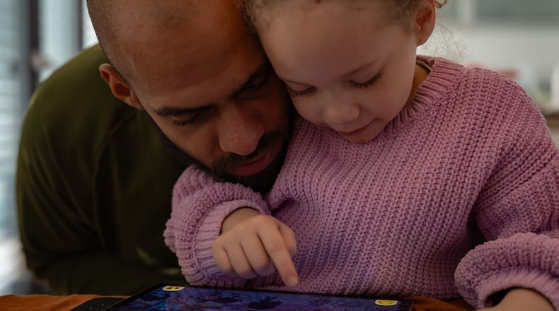 Kasim Edebali and his daughter Yara play a game on a tablet, in Hamburg, Germany. (Patrick Junker/The New York Times 2023)