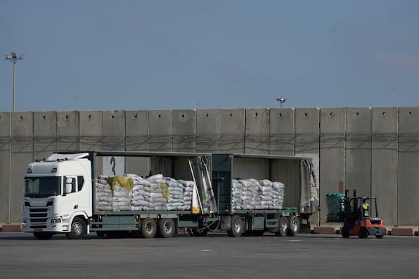 A worker unloads cargo from a truck carrying humanitarian aid for the Gaza Strip at the offload area of the Kerem Shalom border crossing between Israel and Gaza, southern Israel, Thursday, May 22, 2025. (AP Photo/Leo Correa)