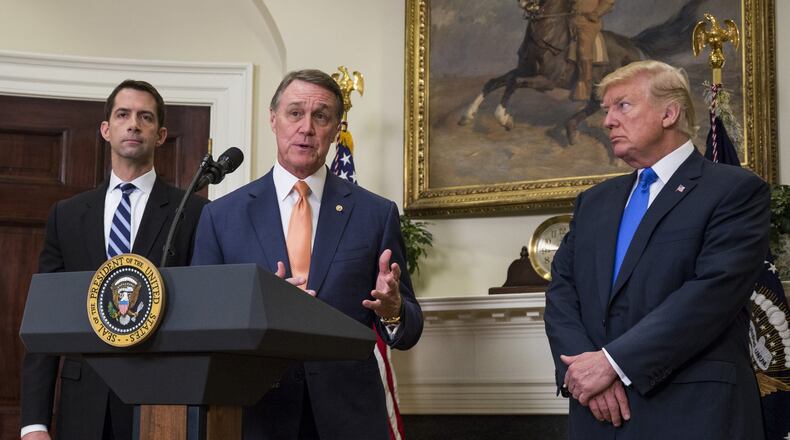 Sen. David Perdue, R-Ga., flanked by Sen. Tom Cotton, R-Ark., left, and President Donald Trump, makes an announcement on the introduction of the Reforming American Immigration for a Strong Economy (RAISE) Act in the White House on Aug. 2, 2017. (Photo by Zach Gibson - Pool/Getty Images)