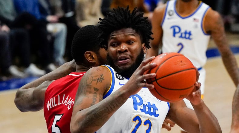 Pittsburgh's John Hugley (23) shoots after getting bthingh Louisville's Malik Williams (5) during the first half of an NCAA college basketball game, Saturday, Jan. 15, 2022, in Pittsburgh. (AP Photo/Keith Srakocic)