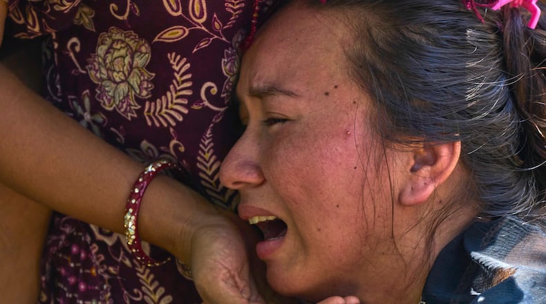 A girl cries as she waits for news of relatives missing after flash floods in Bidur, Nepal's Nuwakot district, Thursday, Aug. 27, 2026. (AP Photo/Niranjan Shrestha)