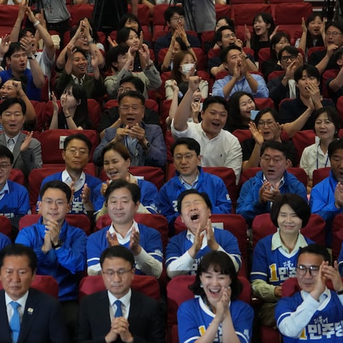 Lawmakers and members of South Korea's ruling Democratic Party react as they watch TV news program about results of exit polls for June 3 nationwide simultaneous local elections at the National Assembly in Seoul, South Korea, Wednesday, June 3, 2026. (AP Photo/Lee Jin-man)