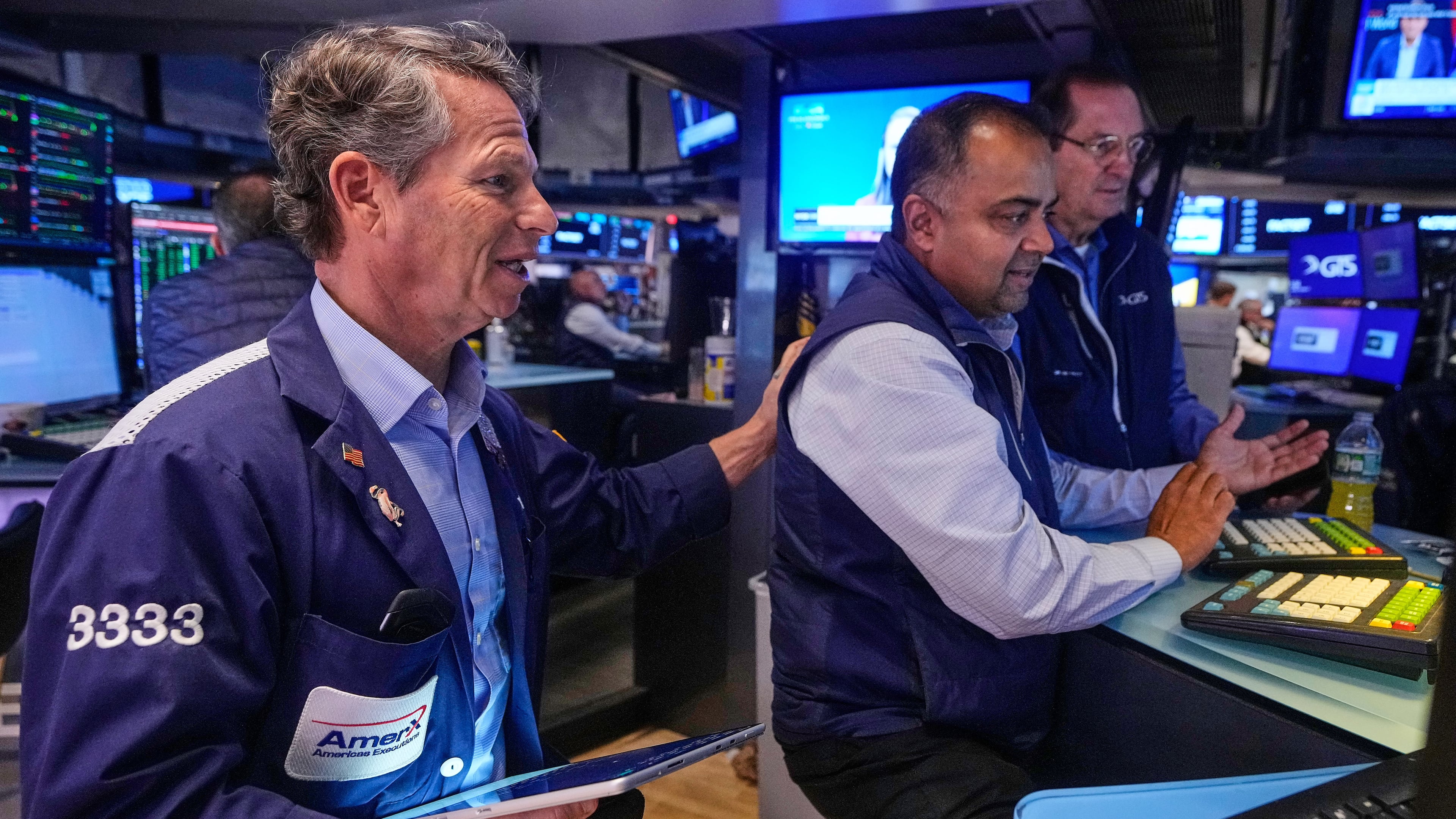 Trader Robert Charmak, left, and specialist Dilip Patel, center, work on the floor of the New York Stock Exchange, Monday, Oct. 13, 2025. (AP Photo/Richard Drew)