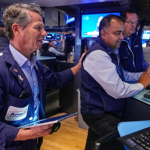 Trader Robert Charmak, left, and specialist Dilip Patel, center, work on the floor of the New York Stock Exchange, Monday, Oct. 13, 2025. (AP Photo/Richard Drew)
