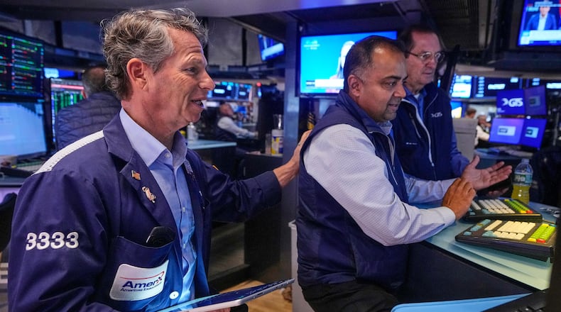 Trader Robert Charmak, left, and specialist Dilip Patel, center, work on the floor of the New York Stock Exchange, Monday, Oct. 13, 2025. (AP Photo/Richard Drew)