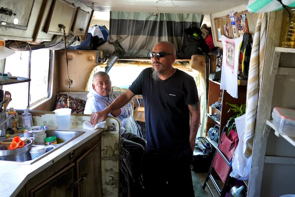 Carlos Perez stands inside an RV, where he lives with his brother, Selvin, left, in the Bayview neighborhood of San Francisco, Monday, July 14, 2025. (AP Photo/Terry Chea)