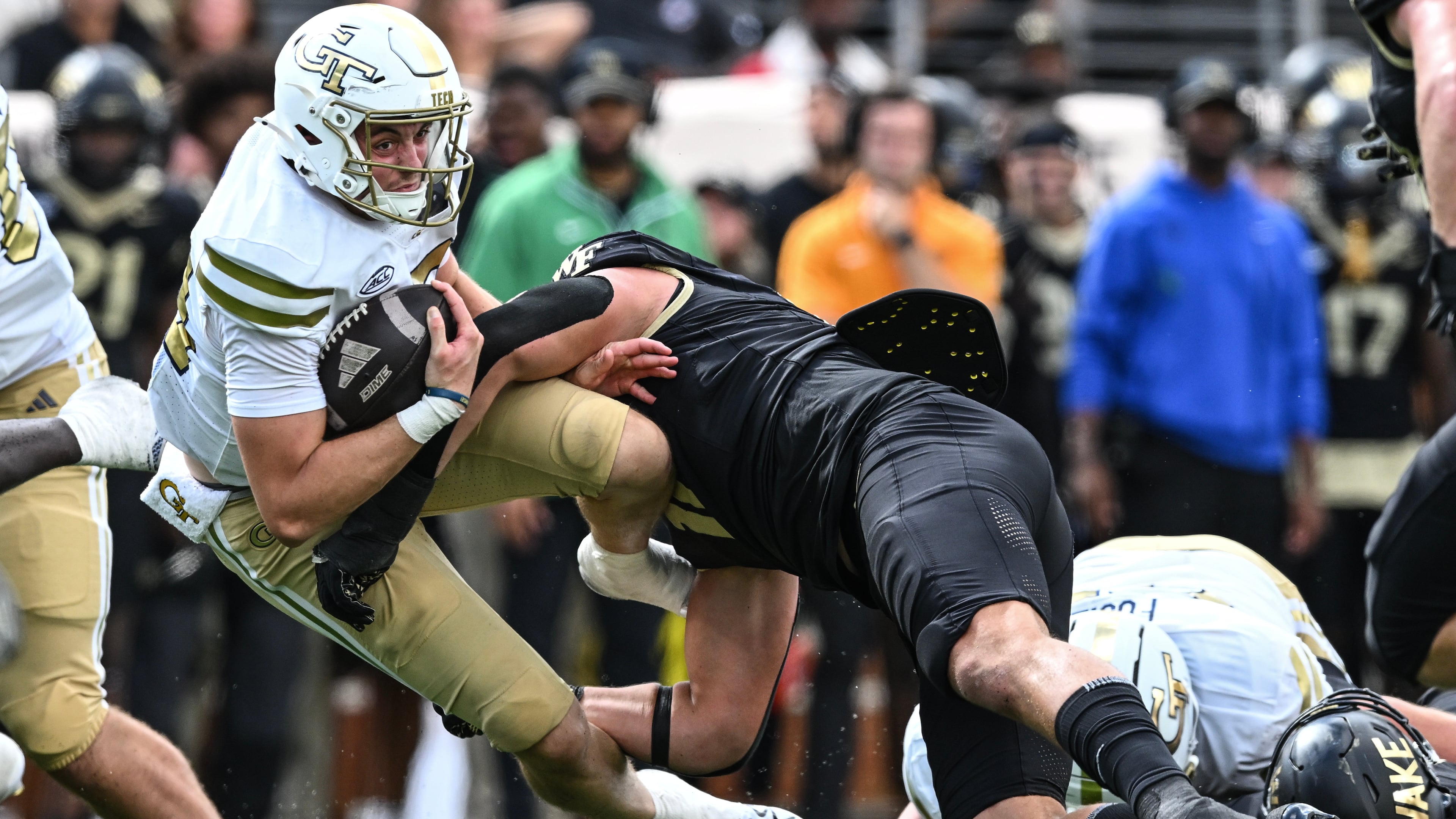 Wake Forest defensive lineman Gabe Kirschke (center) tackles Georgia Tech quarterback Haynes King during the second half Saturday, Sept. 27, 2025, in Winston-Salem, N.C. King led the Yellow Jackets to a game-tying drive with less than two minutes to go in regulation, and he ran for Tech's touchdown in overtime. (Matt Kelley/AP)