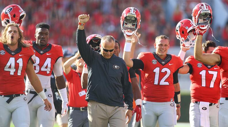 Georgia head coach Mark Richt and the Bulldogs march across the field before a game. Georgia’s issues at the moment are chiefly with the offense, but it goes beyond that.
