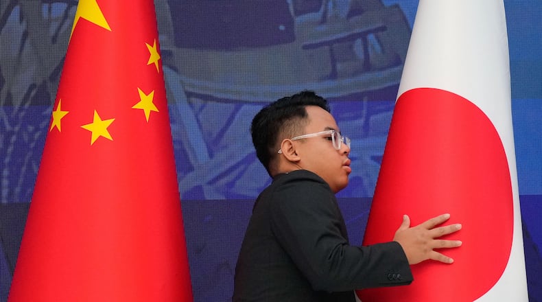 FILE - A staff organise flags from China, left, and Japan before the start of the 28th ASEAN Plus Three Summit in Kuala Lumpur, Malaysia, on Oct. 27, 2025. (AP Photo/Vincent Thian, Pool, File)
