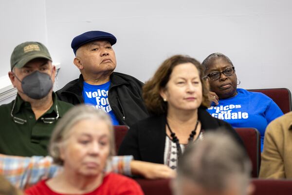 Benjamin and Cheryl Garcia (back row) attend the Rockdale County Board of Commissioners meeting in Conyers in December. Several people called for the shutdown of BioLab. (Arvin Temkar/AJC)