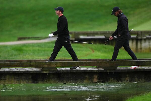 Rory McIlroy, left, of Northern Ireland, and Tommy Fleetwood, of England, walk on the 13th hole during the second round of the Truist Championship golf tournament at the Philadelphia Cricket Club, Friday, May 9, 2025, in Flourtown. (AP Photo/Matt Rourke)