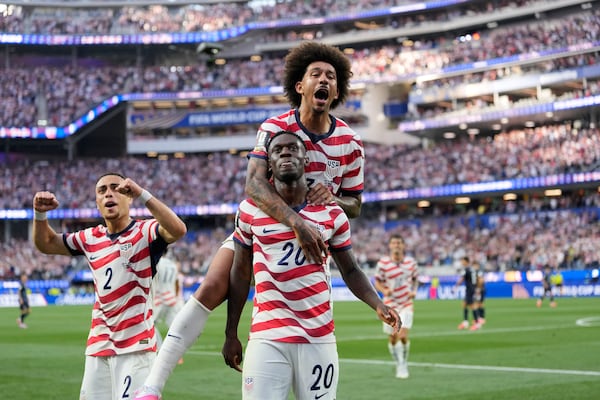The United States' Folarin Balogun (bottom) and teammates celebrate scoring his side's third goal against Paraguay. (Andre Penner/AP)
