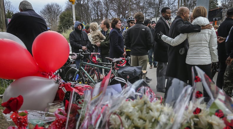A crowd gathers around the site of a memorial for a Grady High School student who was struck while riding her bicycle at 10th Street and Monroe Drive in this file photo from 2016. JOHN SPINK /JSPINK@AJC.COM