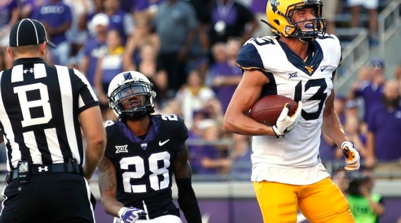 West Virginia wide receiver David Sills V (13) scores on a touchdown pass as TCU cornerback Tony James (28) looks on during the second half of an NCAA college football game Saturday, Oct. 7, 2017, in Fort Worth, Texas. TCU won 31-24. (AP Photo/Ron Jenkins)