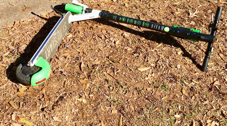 When Decatur passes its electric scooter ordinance, probably later this month, you can no longer ditch them like this. They will have to be parked upright on a hard service and can’t obstruct pedestrians or cars. Bill Banks file photo for the AJC