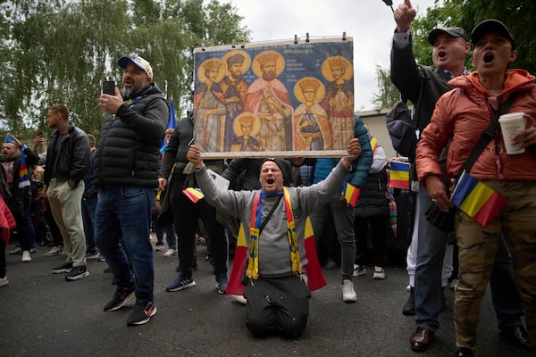 Supporters of Calin Georgescu, the winner of the first round of last year's annulled election, chant slogans during his appearance at a prosecutor's office in Bucharest, Romania, Tuesday, May 27, 2025. (AP Photo/Vadim Ghirda)