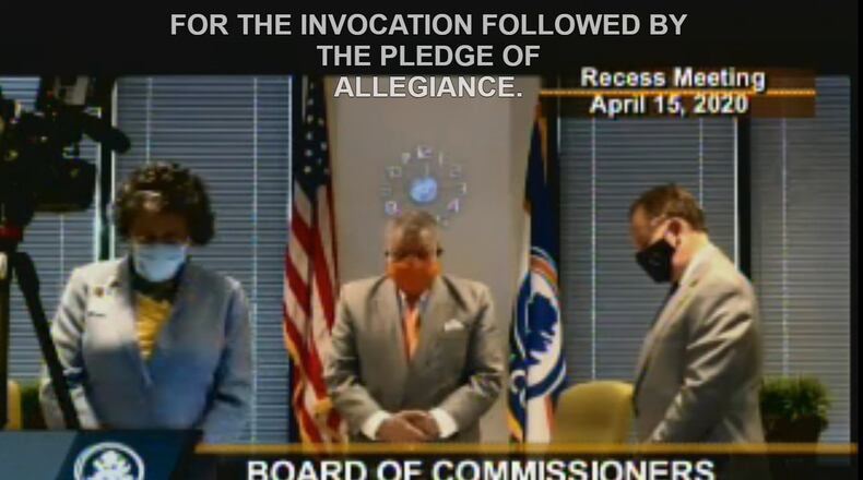 (Left to right) Fulton County Attorney Patrise Perkins-Hooker, Fulton Chairman Robb Pitts and Fulton County Manager Dick Anderson wear face masks to protect themselves from COVID-19 while standing for an invocation to start the April 15, 2020 meeting of the Fulton County Board of Commissioners.