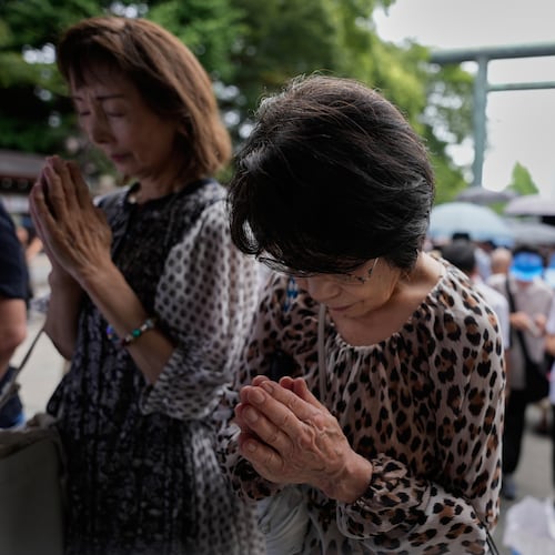 Visitors observe a moment of silence at Yasukuni Shrine, which honors Japan's war dead, including convicted war criminals, as the country marks the 81st anniversary of the end of World War II Saturday, Aug. 15, 2026, in Tokyo. (AP Photo/Eugene Hoshiko)