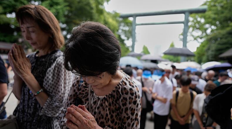 Visitors observe a moment of silence at Yasukuni Shrine, which honors Japan's war dead, including convicted war criminals, as the country marks the 81st anniversary of the end of World War II Saturday, Aug. 15, 2026, in Tokyo. (AP Photo/Eugene Hoshiko)