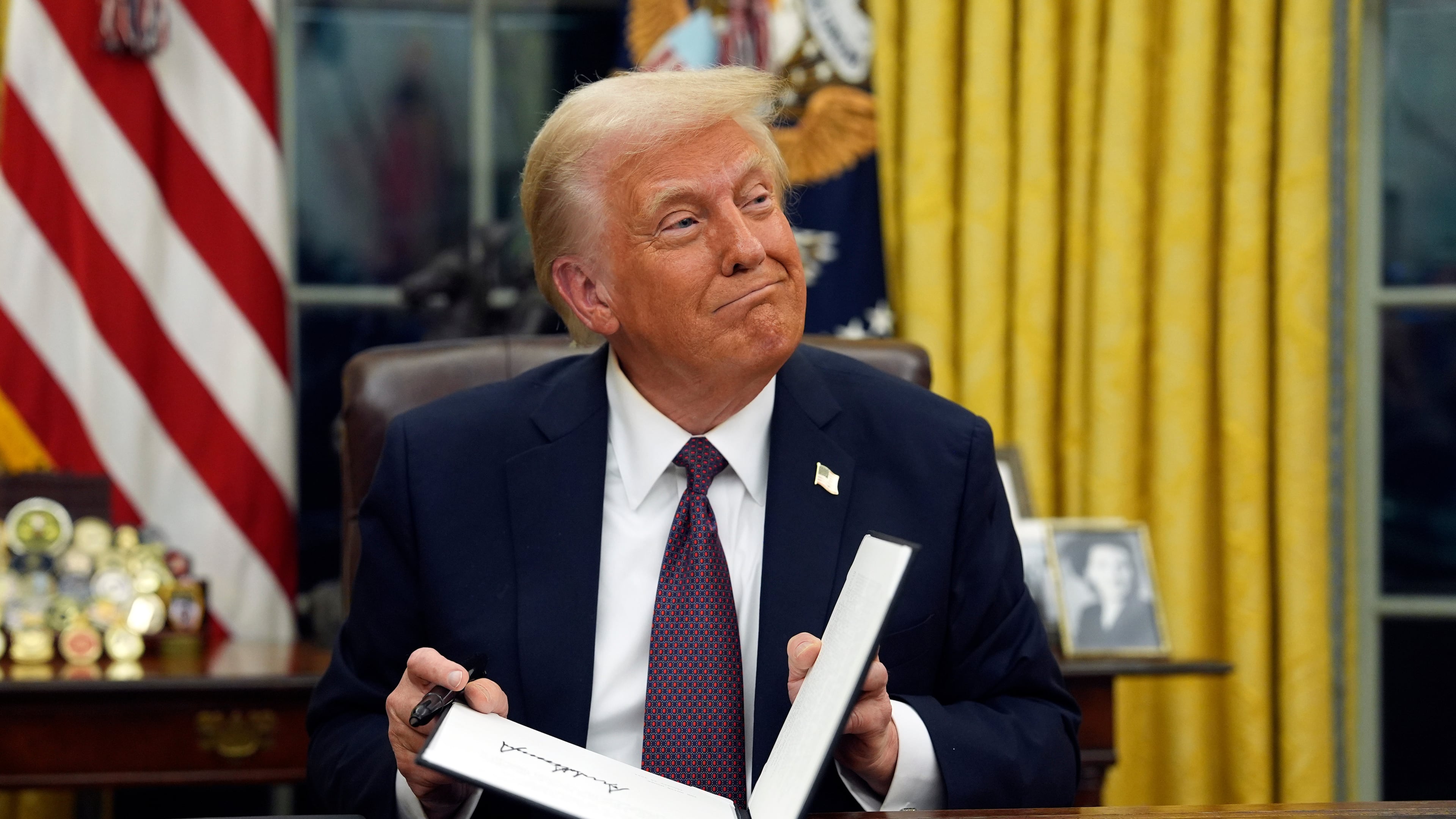 FILE - President Donald Trump signs executive orders in the Oval Office of the White House, Jan. 20, 2025, in Washington. (AP Photo/Evan Vucci, File)