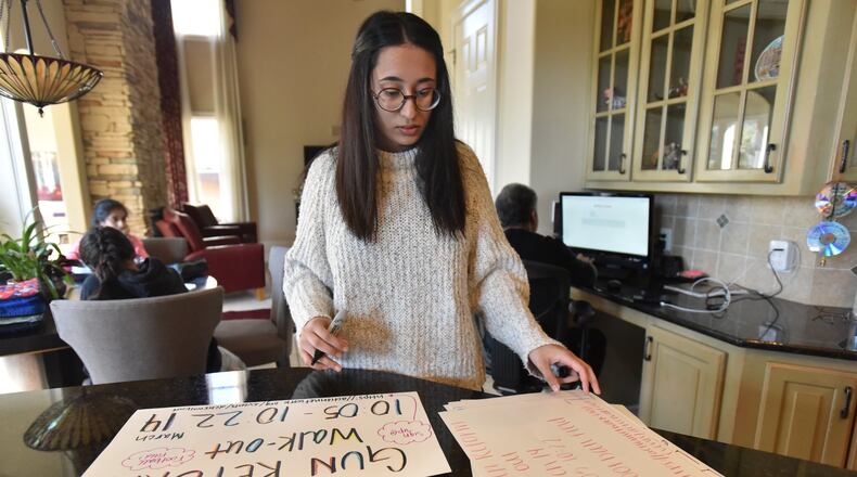 Anam Hussain, 16, shows signs, she and her friends made, at her home in Douglasville. Hussain, 16, is one of students who are involved in organizing and are planning to participate in the coming school walkouts over gun violence on March 14.  HYOSUB SHIN / HSHIN@AJC.COM