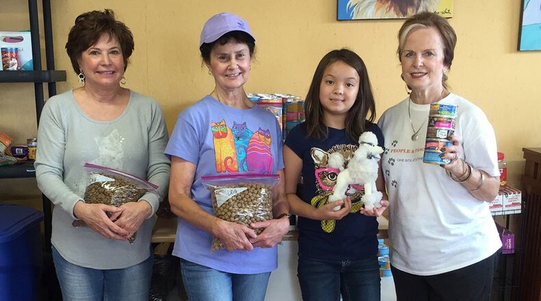 Volunteers Sandy Allen (from left), Ann Clutter, Natalya Sutaro and her grandmother Joyce Ahmad, the founder of People and Paws, meet at the charity’s expanded space to bag food. CONTRIBUTED