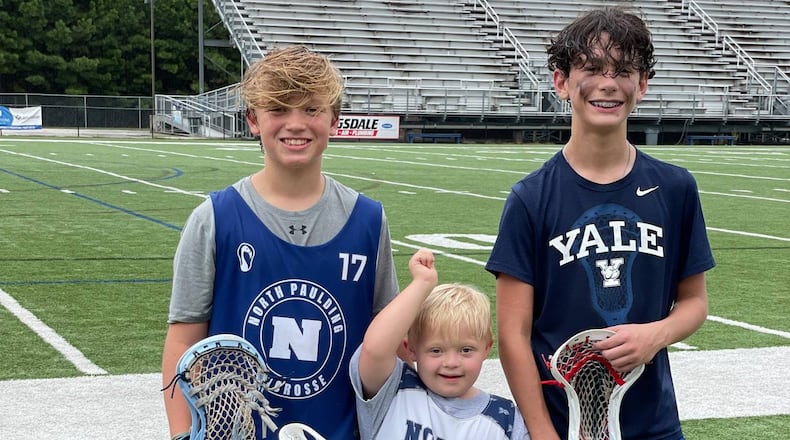Watson and Max Howey stand with Grayson Carvel, right, the 13-year-old who created Giving with LAX, an effort to get special needs kids involved in lacrosse. Courtesy of Lindsey Carvel