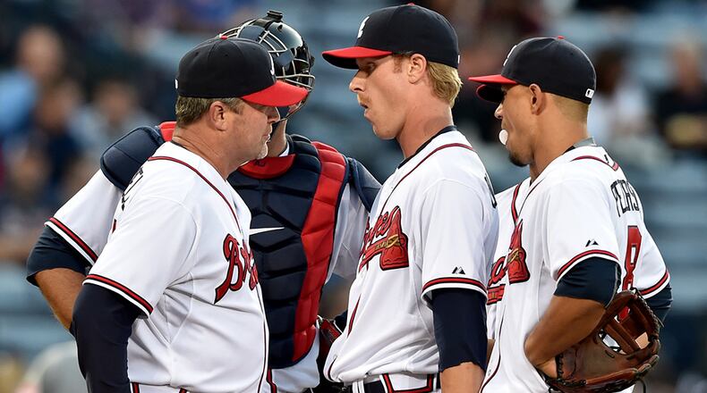 Atlanta Braves pitching coach Roger McDowell (left) makes a first inning visit to the mound to talk with pitcher Mike Foltynewiez, who gave up three hits and two runs in the first inning against the Cincinnati Reds at Turner Field Friday, May 1, 2015.