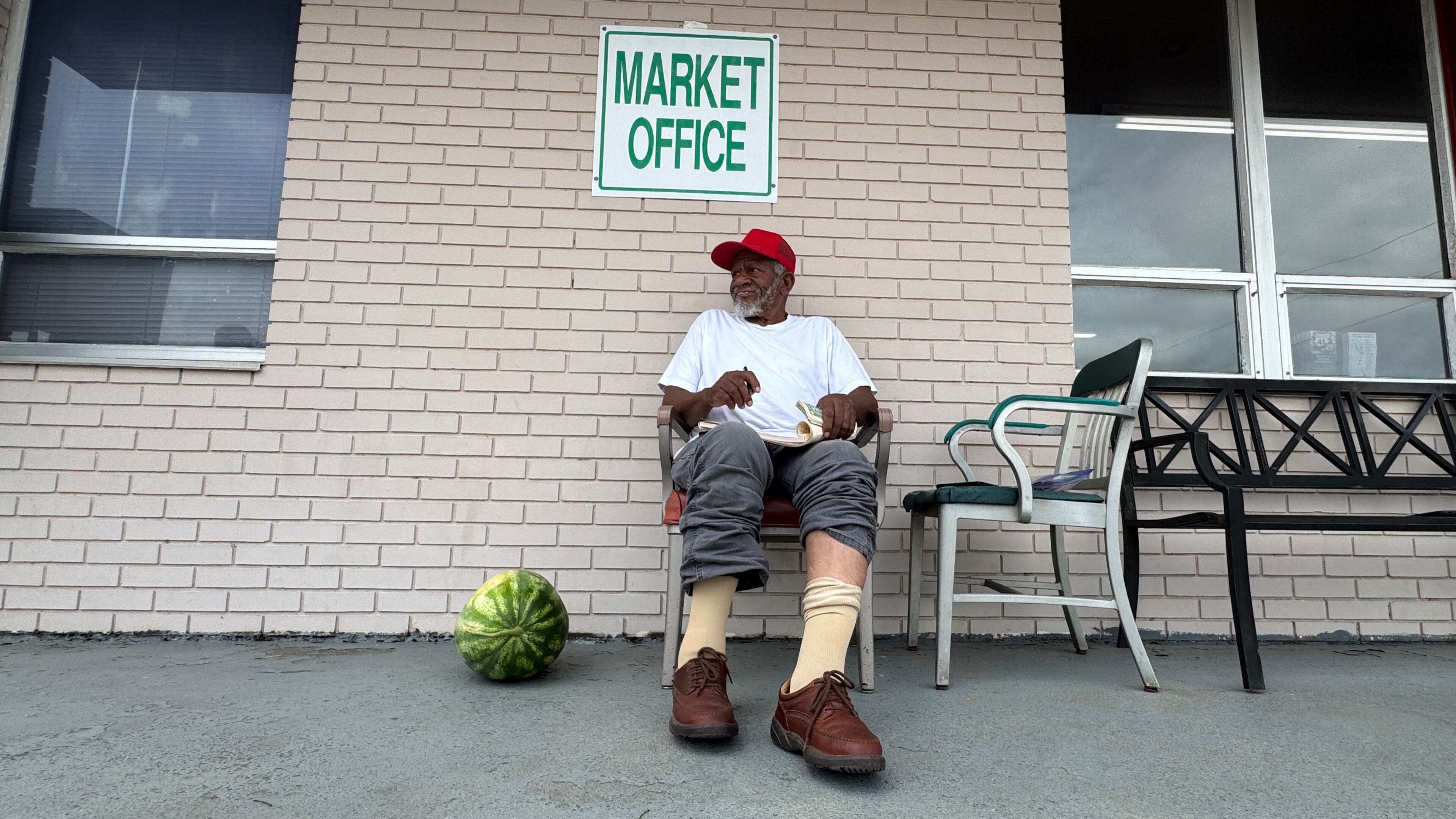 Gate monitor Johnny C. Daniels oversees an entrance at the Cordele State Farmers Market. (Joe Kovac Jr./AJC)