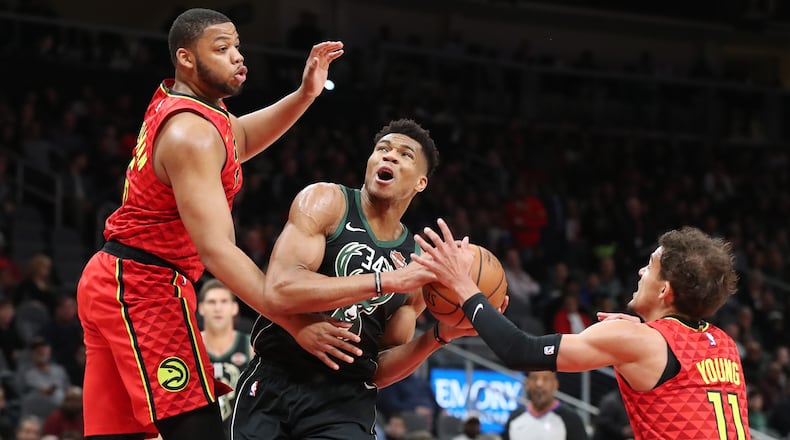 Milwaukee Bucks Giannis Antetokounmpo drives to the basket against an Atlanta Hawks double team by Trae Young and Omari Spellman during the first half in a NBA basketball game at State Farm Arena on Sunday, Jan. 13, 2019, in Atlanta.    Curtis Compton/ccompton@ajc.com