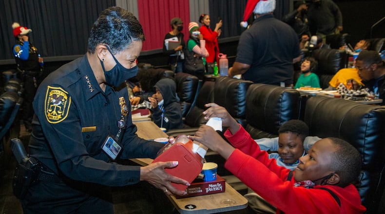 DeKalb County police Chief Mirtha Ramos helps Josiah Owens as the Police Athletic League hosted a "Movie with a Cop" event at the Movie Tavern in Tucker. PHIL SKINNER, FOR THE ATLANTA JOURNAL-CONSTITUTION