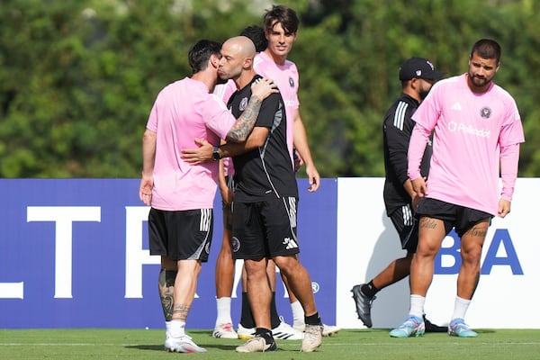 Inter Miami head coach Javier Mascherano, second from left, greets forward Lionel Messi, left, during a training session Friday, June 13, 2025, in Fort Lauderdale, Fla. in preparation for a Club World Cup soccer match Saturday. (AP Photo/Lynne Sladky)