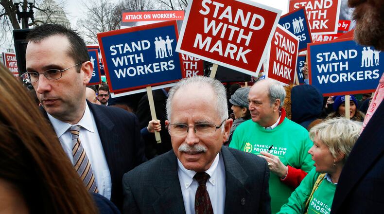 Illinois government employee Mark Janus, center, turns after thanking supporters outside the Supreme Court, Monday, Feb. 26, 2018, in Washington. The Supreme Court takes up a challenge Monday in a case that could deal a painful financial blow to organized labor. The court is considering a challenge to an Illinois law that allows unions representing government employees to collect fees from workers who choose not to join. (AP Photo/Jacquelyn Martin)