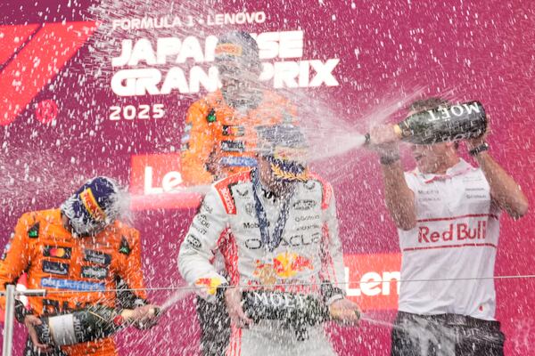 Red Bull driver Max Verstappen of the Netherlands, center, is sprayed champagne by second placed, McLaren driver Lando Norris of Britain, left, and third place McLaren driver Oscar Piastri of Australia, top, on the podium after the Japanese Formula One Grand Prix at the Suzuka Circuit in Suzuka, central Japan, Sunday, April 6, 2025. (AP Photo/Shuji Kajiyama