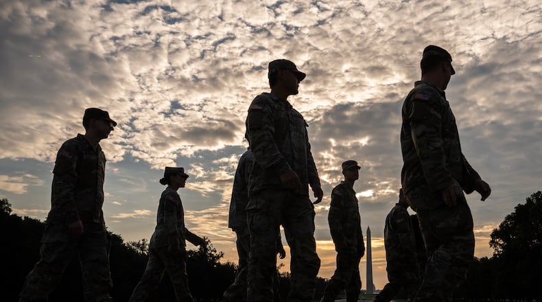 Members of the National Guard walk past the Lincoln Memorial Reflecting Pool before the March on Washington, Friday, Aug. 28, 2026, in Washington. (AP Photo/Julia Demaree Nikhinson)