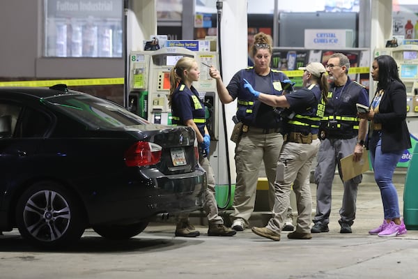 Multiple agencies investigate the scene of the police shooting at a gas station along Fulton Industrial Boulevard. (John Spink/AJC file photo)