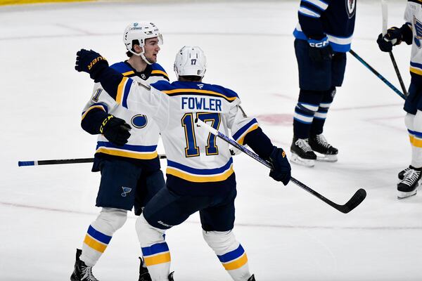 St. Louis Blues' Jimmy Snuggerud, left, celebrates after his goal against the Winnipeg Jets with Cam Fowler (17) during the first period of Game 2 of a first-round NHL hockey playoff series in Winnipeg, Manitoba, Monday April 21, 2025. (Fred Greenslade/The Canadian Press via AP)