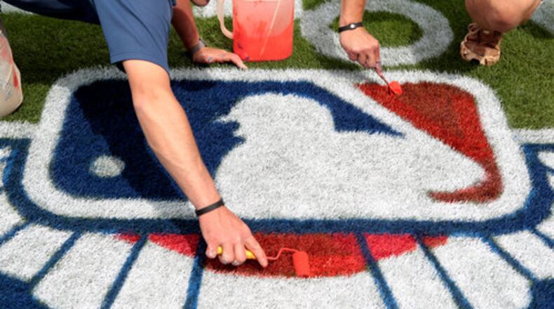 Atlanta Braves grounds crew members put some finishing touches on the MLB logo portion of one of two "Opening Week" logos on the field in preparation for the Braves home opener tomorrow at Turner Field Thursday afternoon in Atlanta, Ga., April 7, 2011.