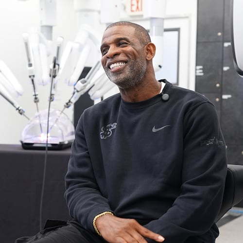 Colorado head football coach Deion Sanders talks about working the Da Vinci robotic surgical machine used to remove his cancerous bladder last year during a demonstration of the device Tuesday, June 23, 2026, in Boulder, Colo. (AP Photo/David Zalubowski)