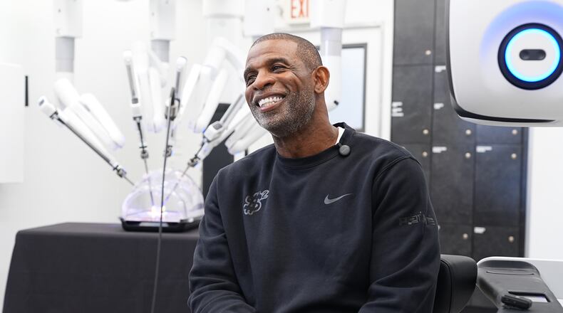 Colorado head football coach Deion Sanders talks about working the Da Vinci robotic surgical machine used to remove his cancerous bladder last year during a demonstration of the device Tuesday, June 23, 2026, in Boulder, Colo. (AP Photo/David Zalubowski)