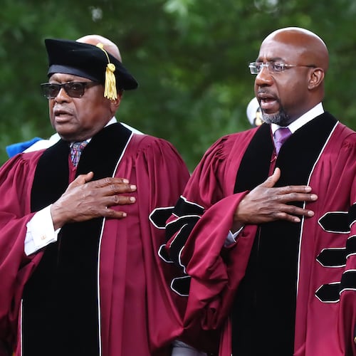 Rep. James E. Clyburn (left) of South Carolina, who received the Honorary Doctor of Laws degree, and Sen. Raphael G. Warnock (right), of Georgia, who received the Honorary Doctor of Humane Letters degree and also deliverd the commencement address, put their hands on their hearts for the presentation of colors and "The Star-Spangled Banner" during the Morehouse College 138th Commencement Ceremony on Sunday, May 15, 2022, in Atlanta. (Curtis Compton/AJC)